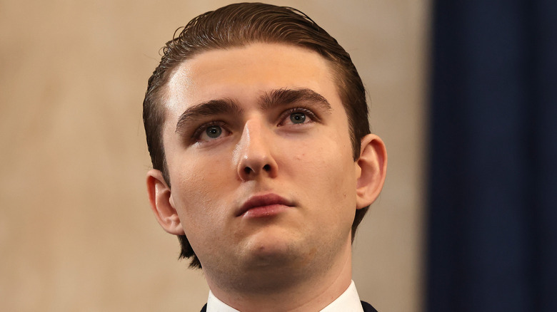 Barron Trump posing in a suit at President Donald Trump's inauguration.
